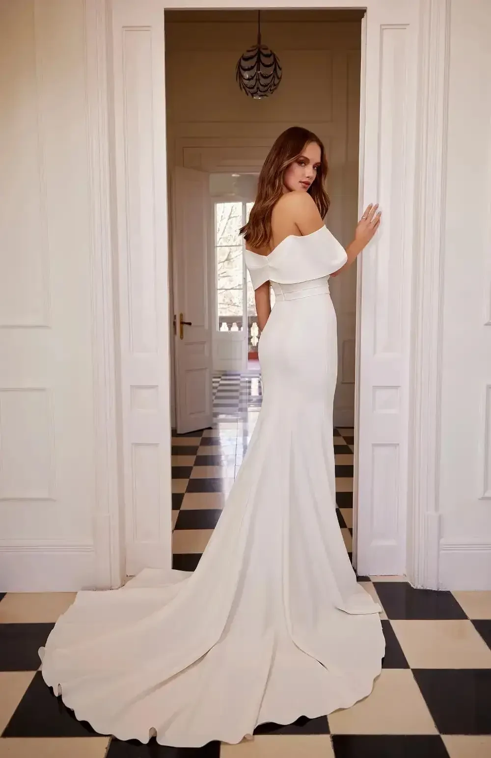 model is wearing an off the shoulder fit and flare bridal gown