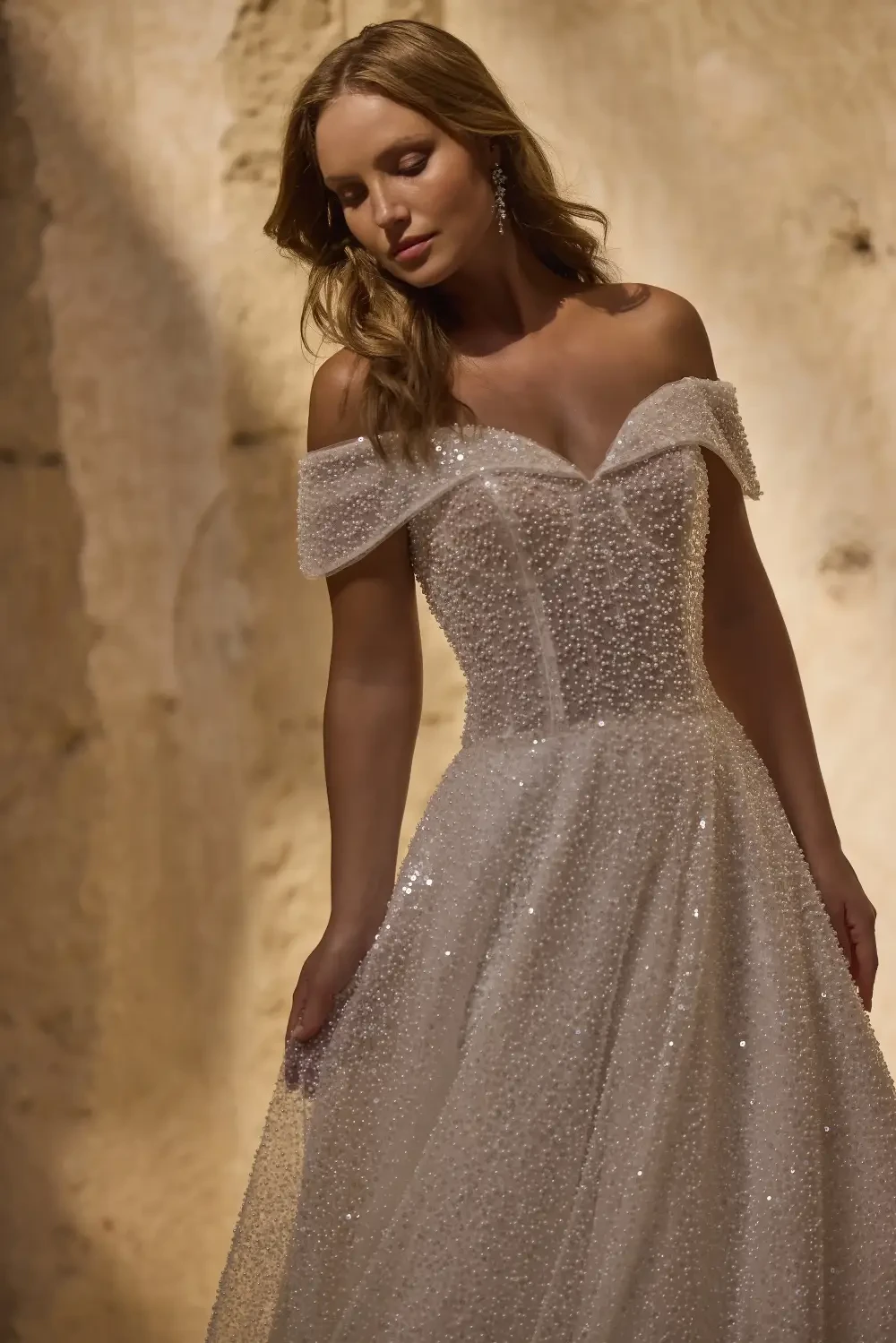 model is wearing an off the shoulder sweetheart wedding dress