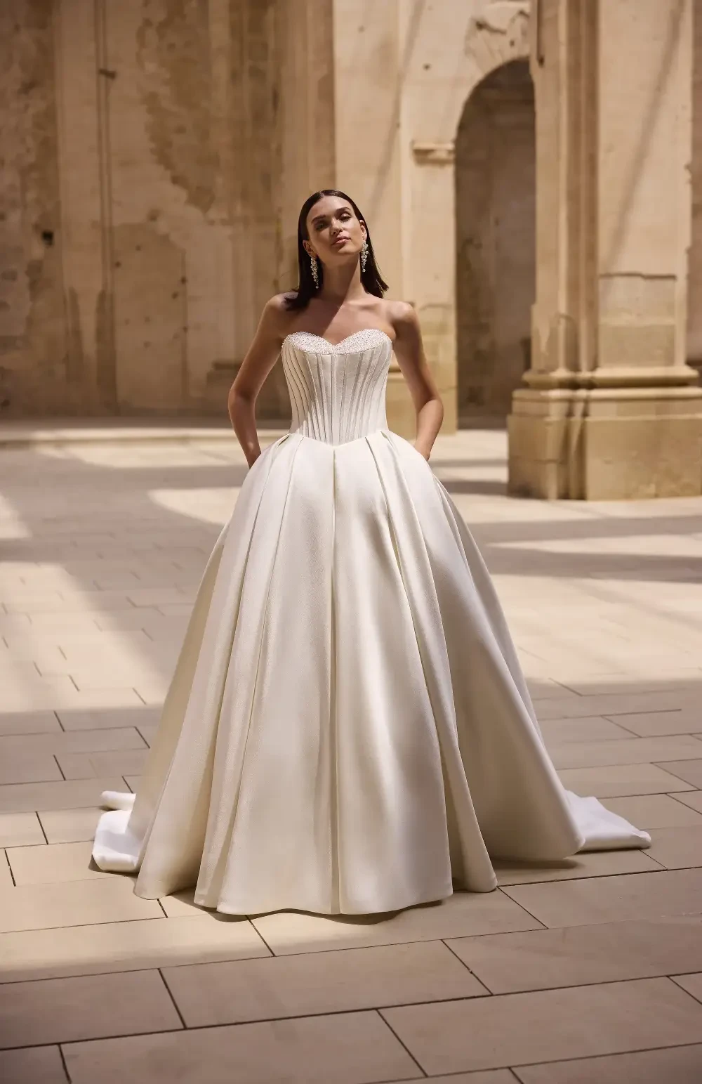 model is wearing a strapless ball gown