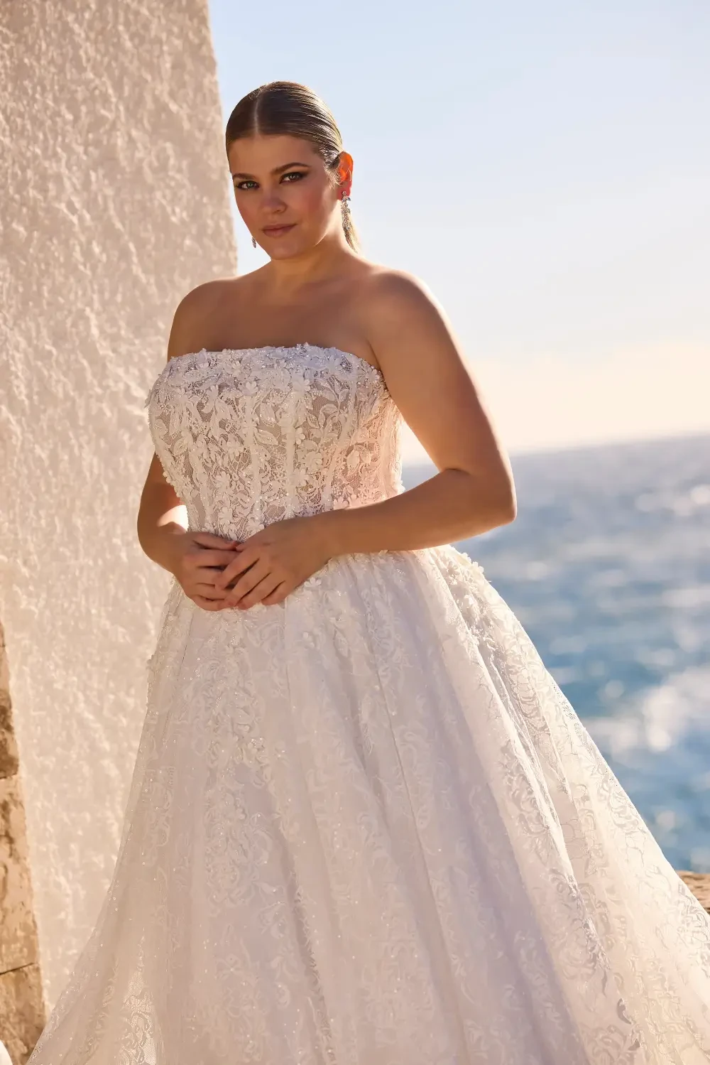model is wearing a plus size strapless wedding dress