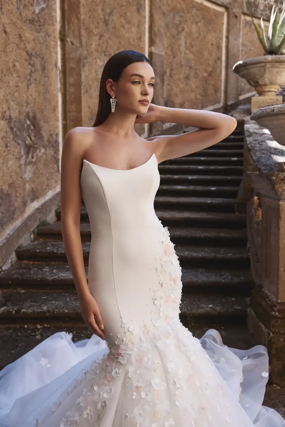 model is wearing a strapless cat eye neckline wedding gown