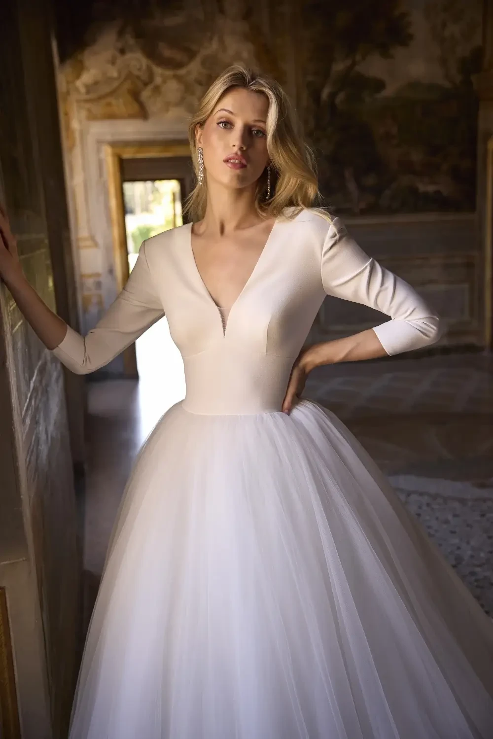 model is wearing a long sleeve v-neckline wedding dress