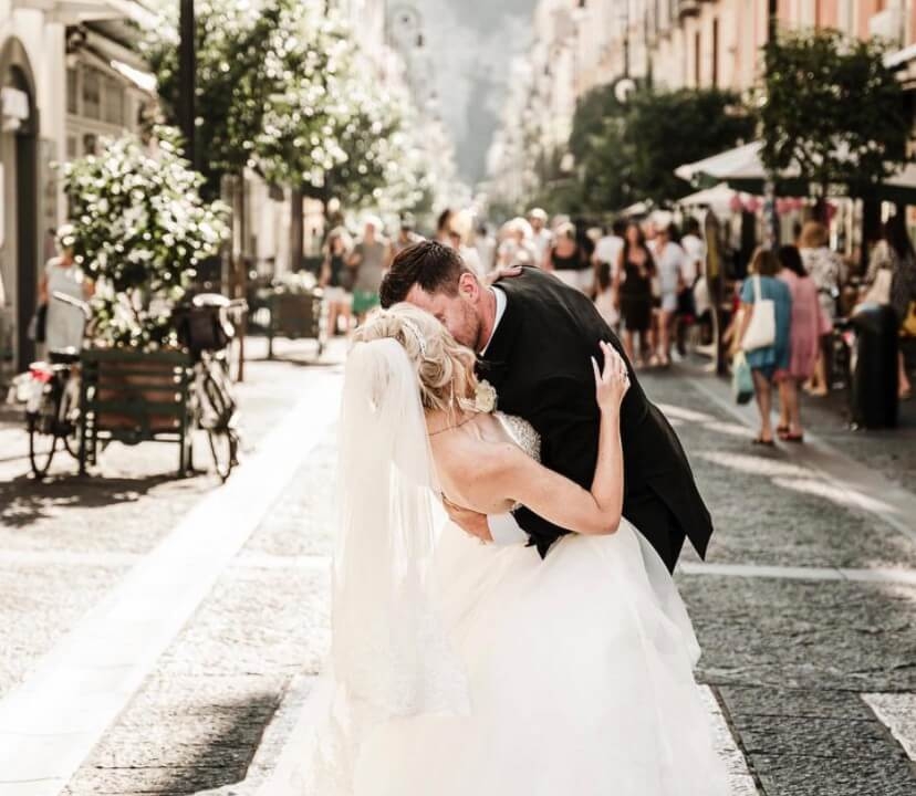 Сouple wearing a white gown and a black suit at the street